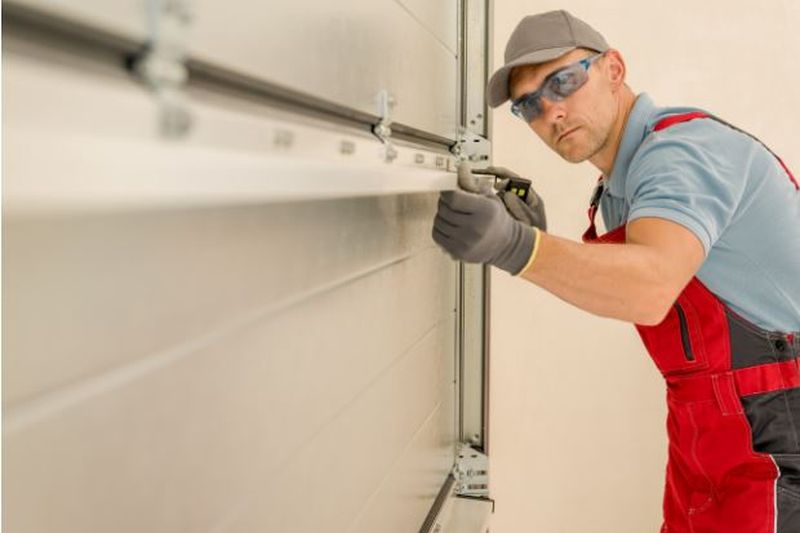 M&M Garage Door technician completing a panel install — fixed right and guaranteed